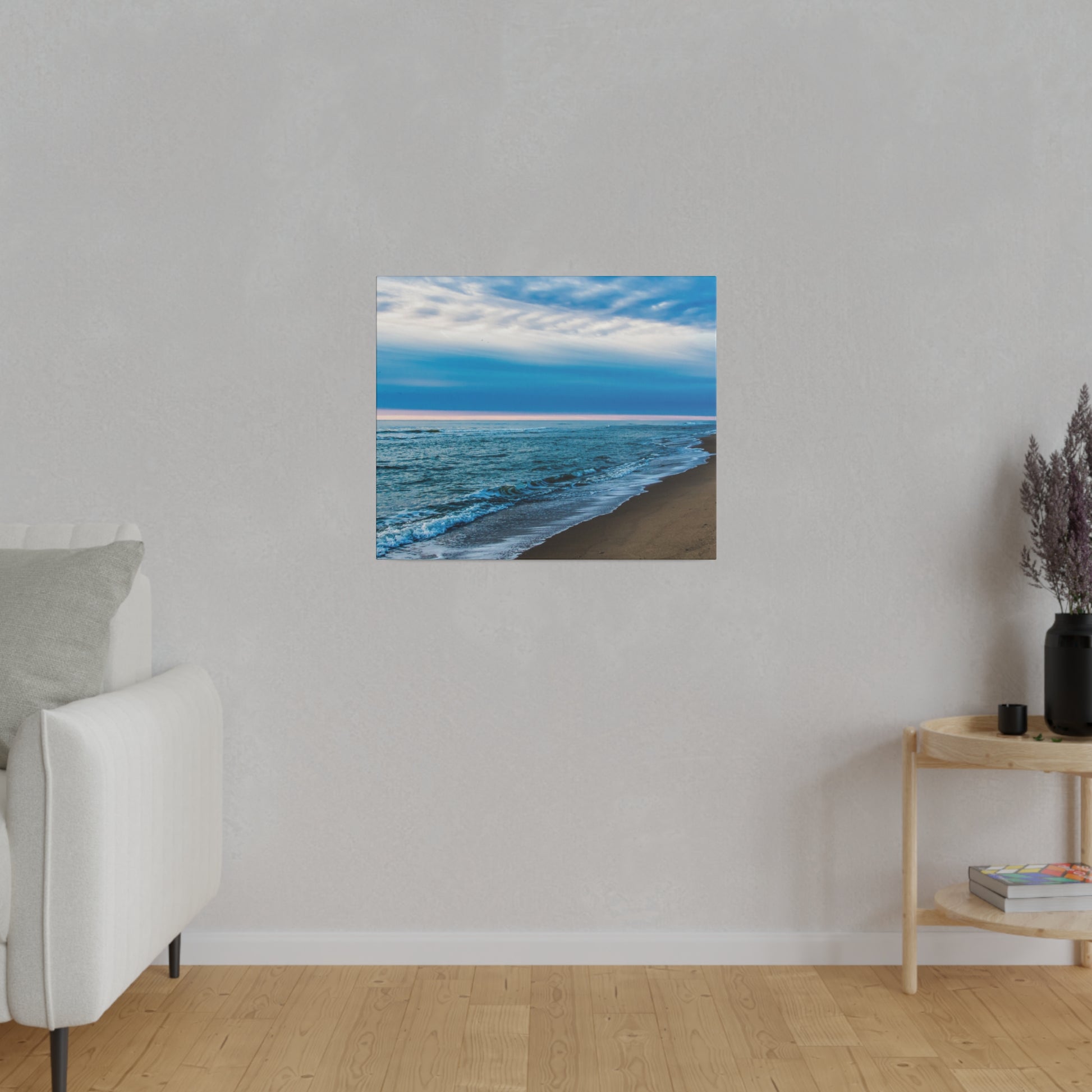 Square wall art print of a blue ocean beach with waves on a beige sandy shore, mounted on a light gray wall.