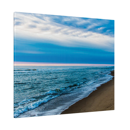 Canvas print showing a sandy beach with blue ocean waves and a cloudy sky above.