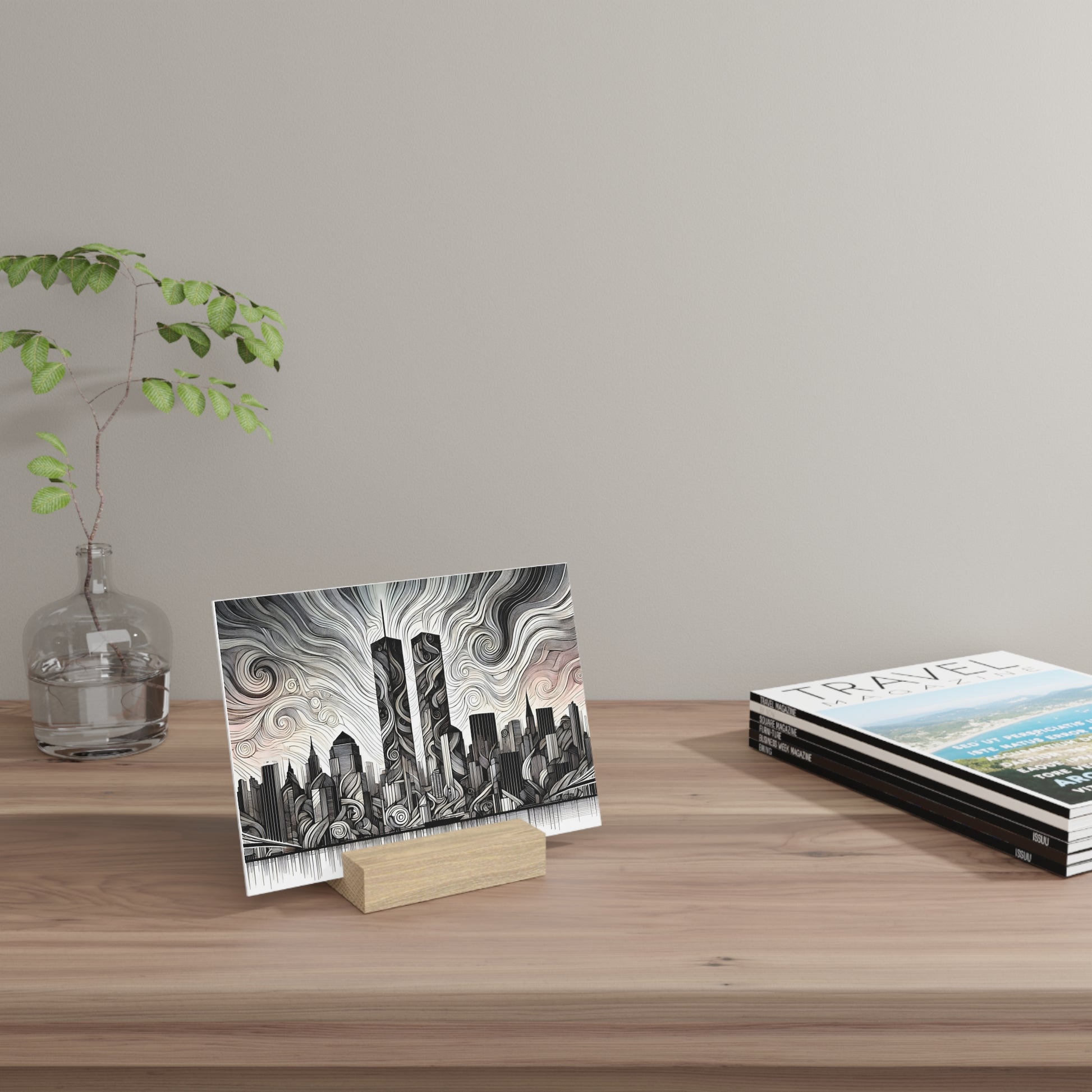 Black and white city skyline illustration card on a small wooden stand, beside a glass vase and a stack of travel magazines on a wooden