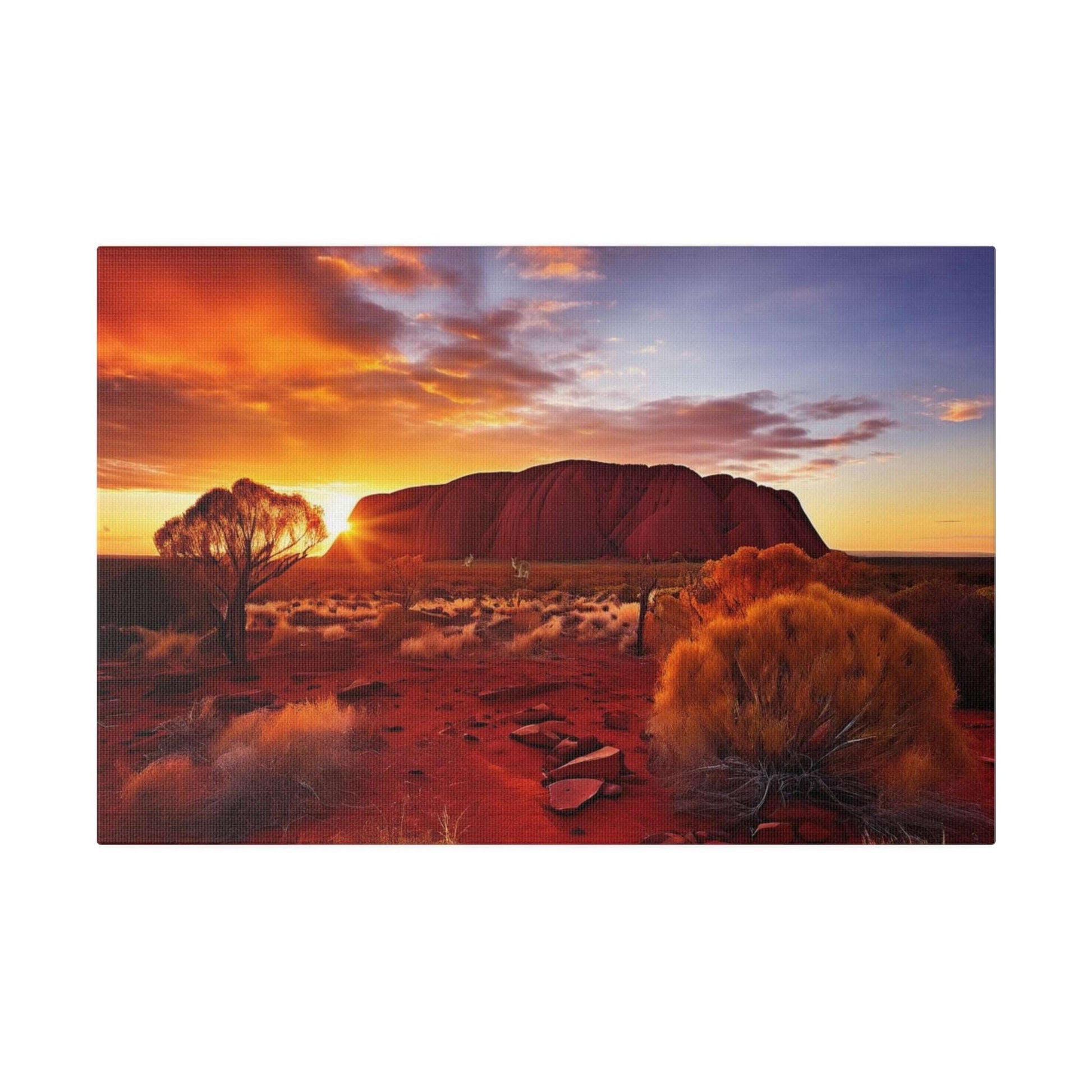 Desert landscape canvas print depicting Uluru at sunset with orange–purple sky, red sand, and sparse shrubs.