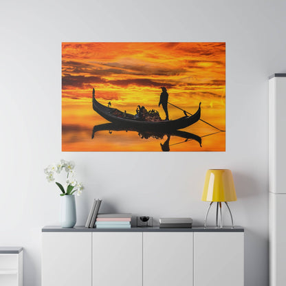 Wall art showing a black gondola with passengers and a gondolier against an orange sunset, reflected on calm water.