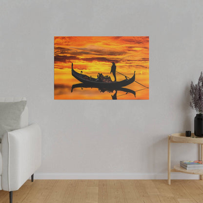 Orange sunset gondola scene with a silhouette of a gondolier steering a boat on calm water.