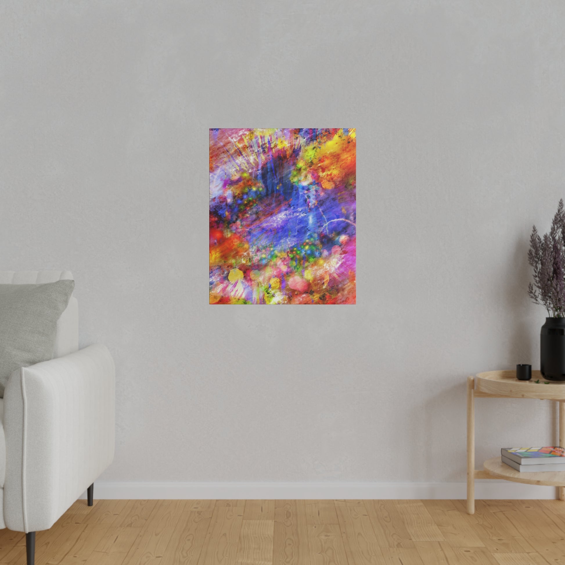 Abstract, multicolor spray-painted canvas hanging on a light gray wall in a minimalist living room.