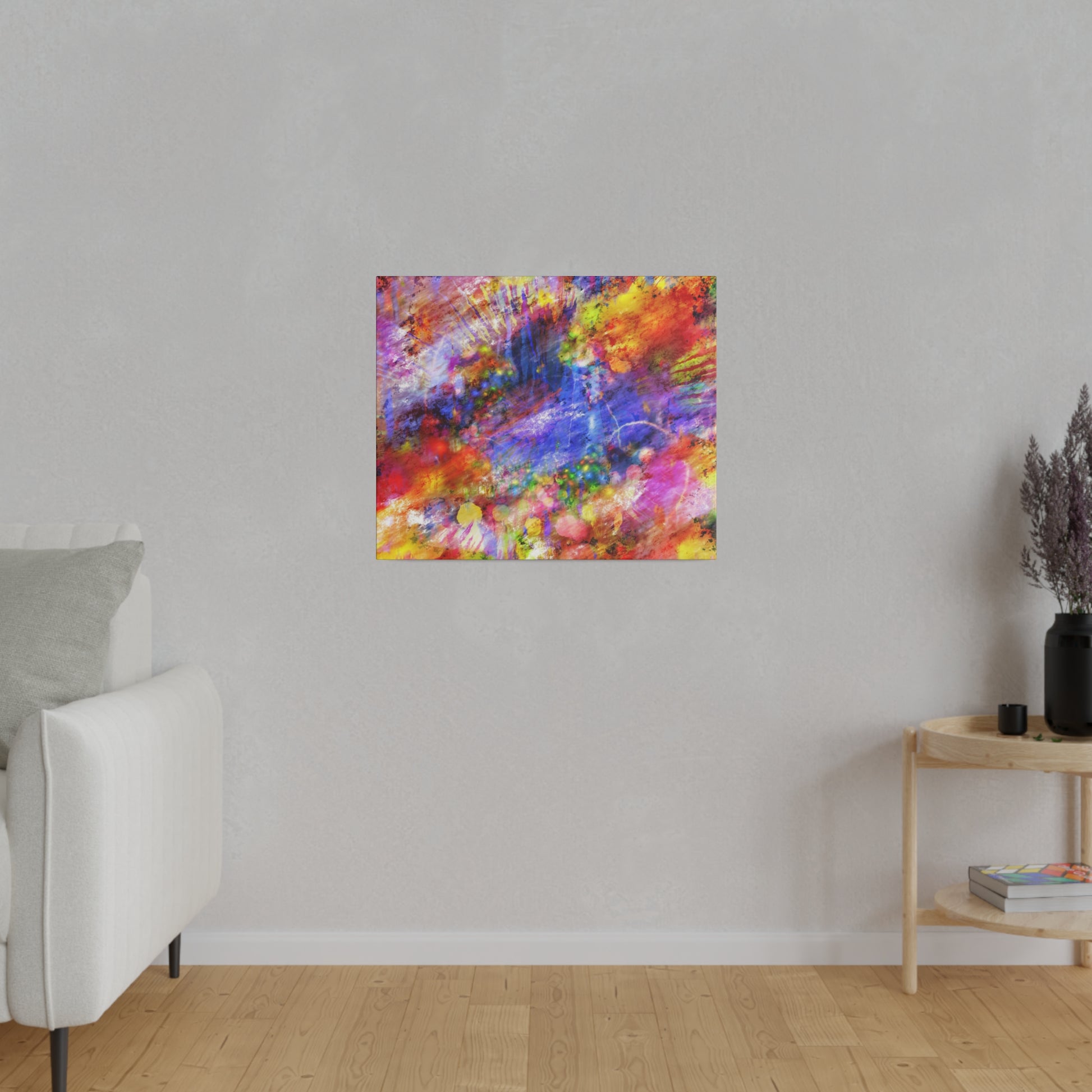 Colorful abstract canvas painting with red, blue, yellow splashes hung on a light gray wall in a living room.