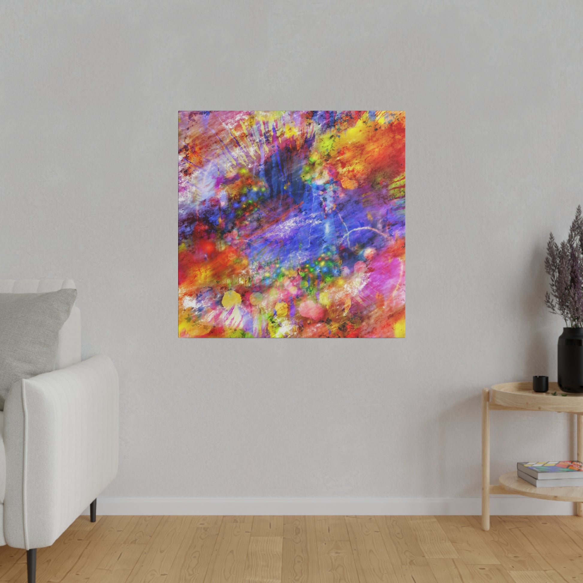 Square abstract painting with vivid multicolor splashes (red, blue, yellow) hung on a light gray living room wall.