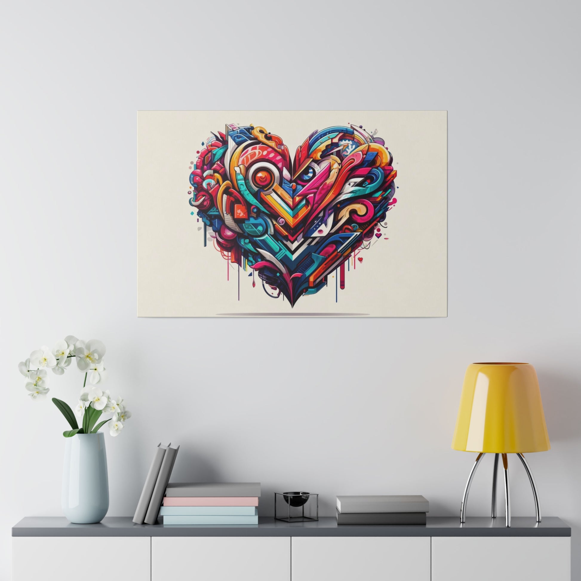 Colorful graffiti-style heart painting on a beige wall above a shelf with a pale blue vase, books, and a yellow lamp.