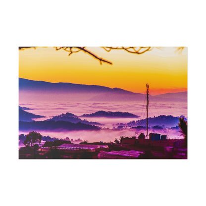 Sunrise over rolling hills with purple fog, orange sky, and a tall radio tower by a small town.