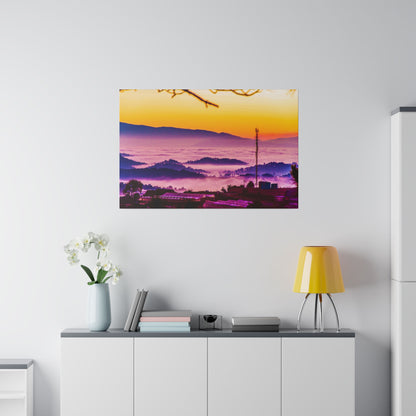 Colorful landscape print of a sunrise over layered purple mountains, mounted on a light wall above a white cabinet.