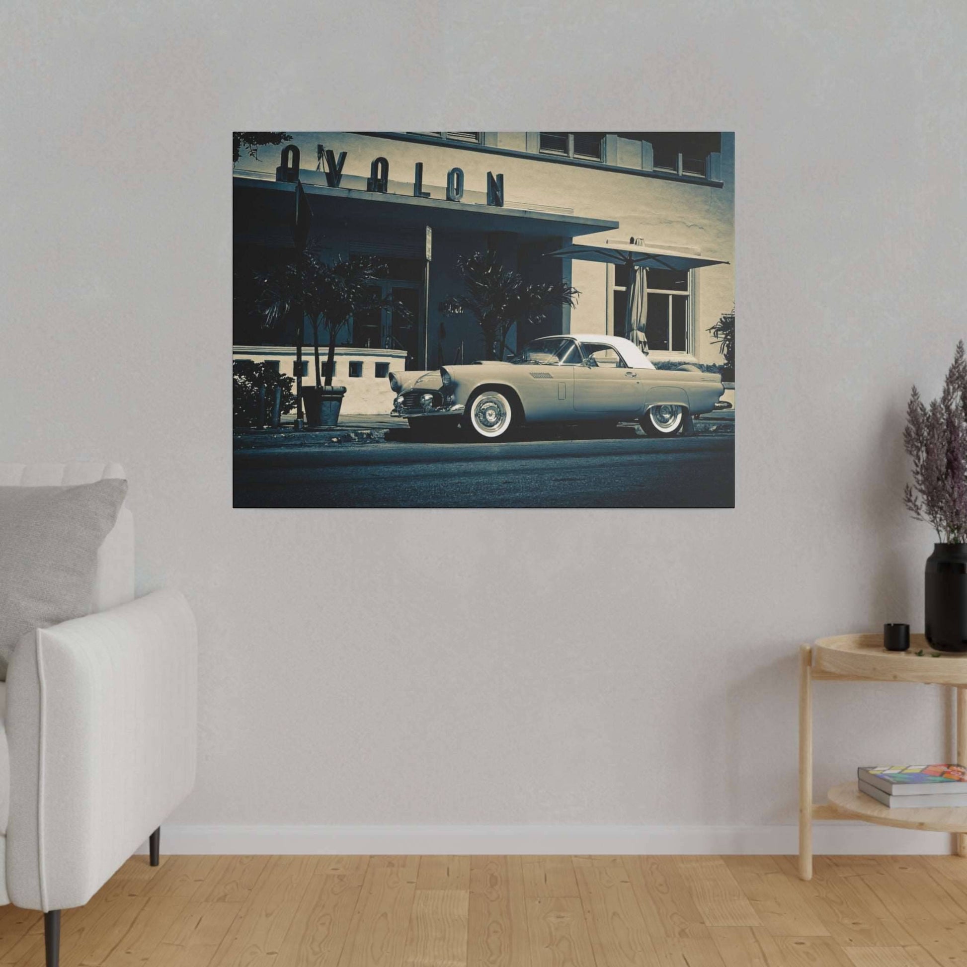 Framed vintage photograph of a light blue classic car parked on a street, hung on a beige living room wall.