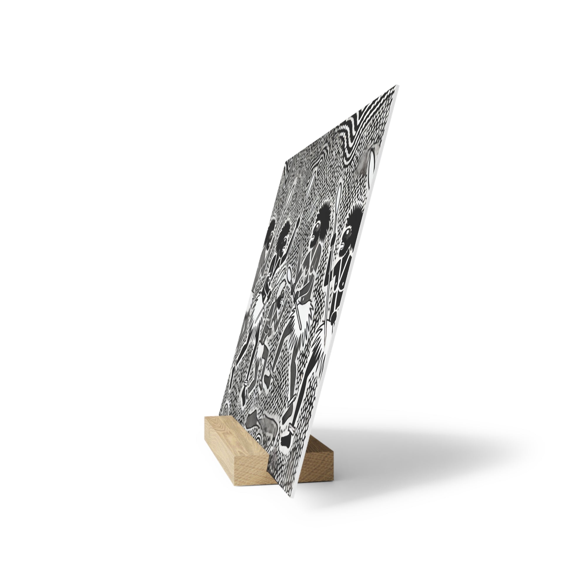 Black-and-white patterned poster leaning on a small light wooden block stand on a white background.
