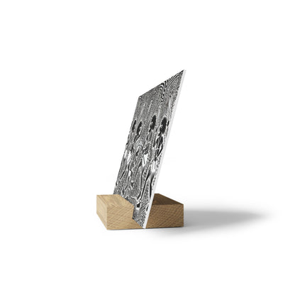 Black-and-white patterned poster mounted on a light wooden wedge stand, angled upright.