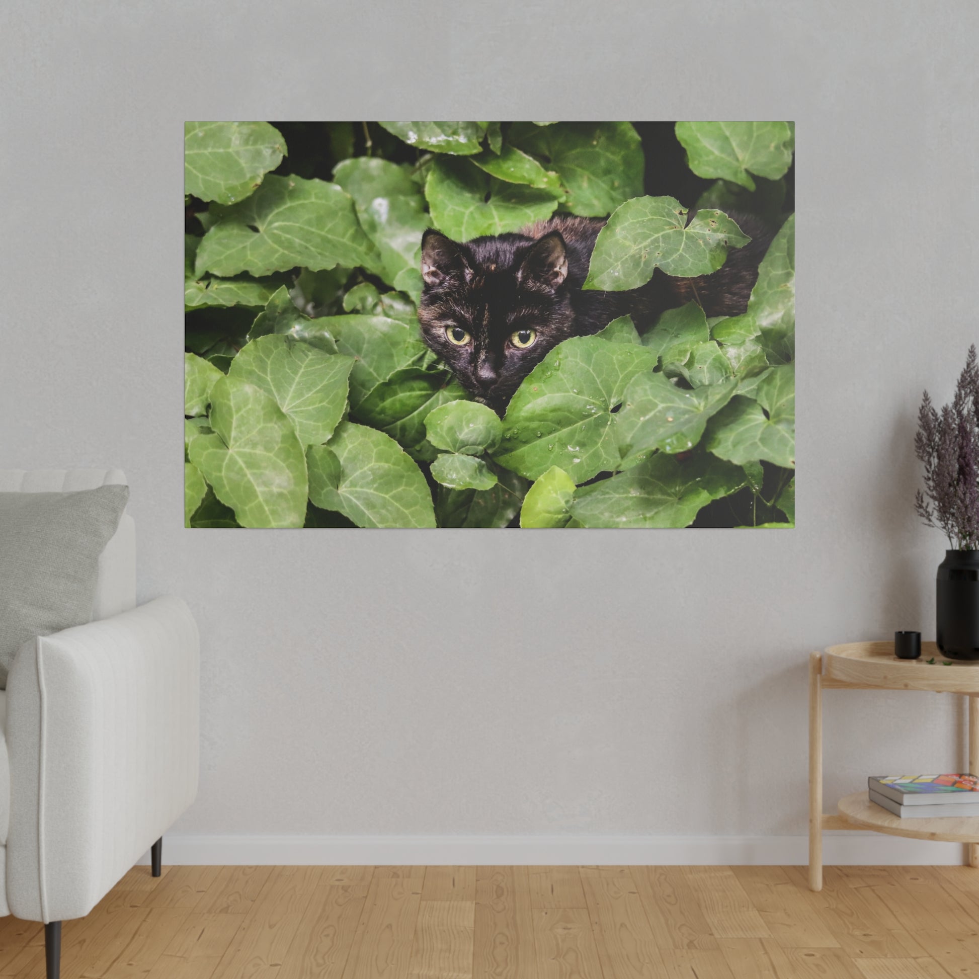 Black cat hiding among dense green ivy leaves, its yellow eyes peering through.