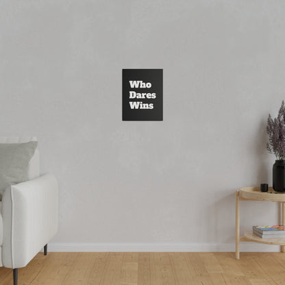 Light gray living room wall with a small black poster reading "Who Dares Wins" centered above a white sofa and wooden side table.