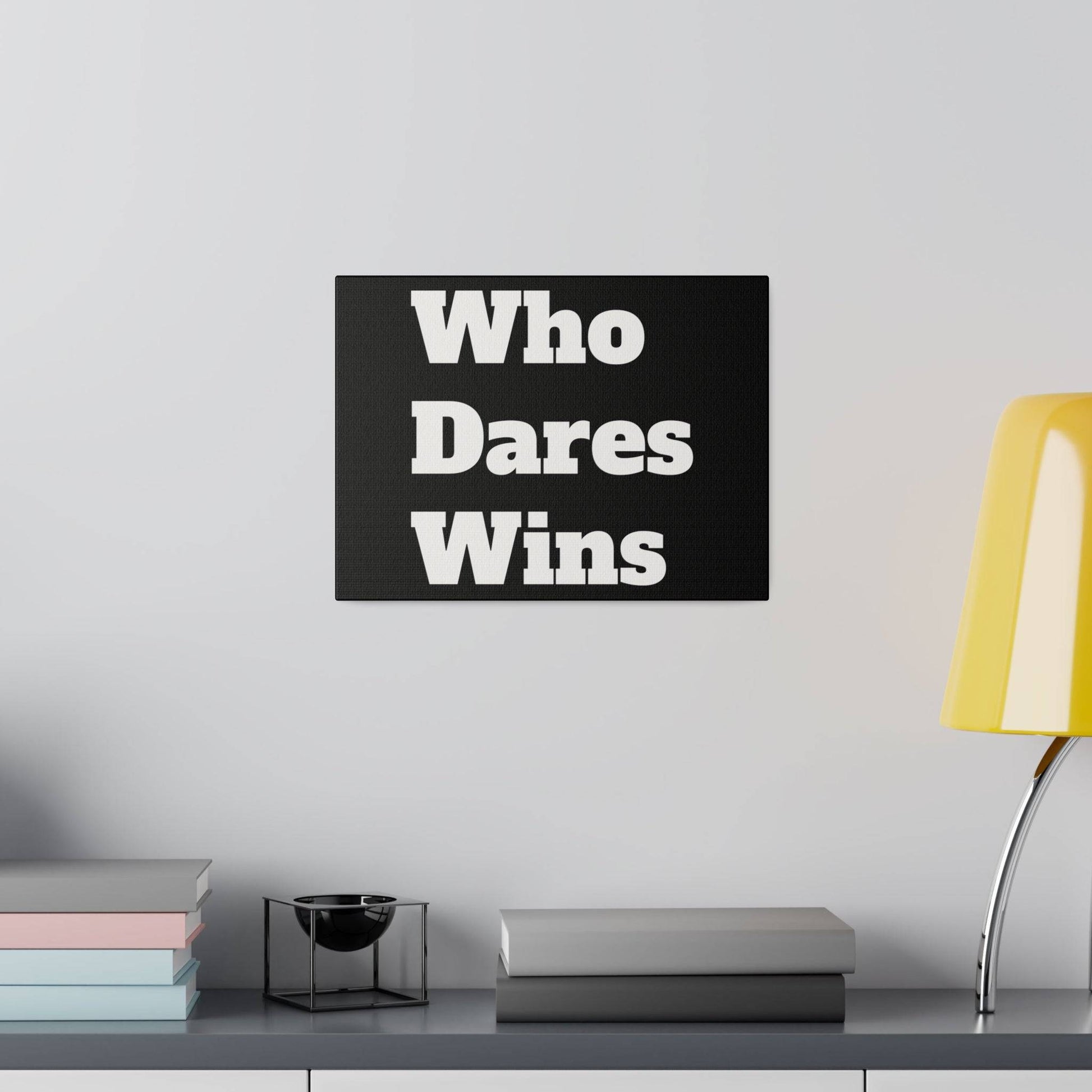 Black rectangular sign with large white text "Who Dares Wins" mounted on a light gray wall above a shelf.