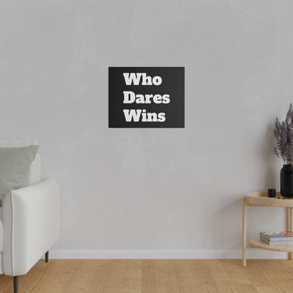 Black square poster with white bold text “Who Dares Wins” hung on a light gray wall in a minimalist living room.
