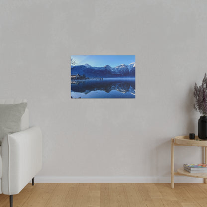 Small wall-mounted photo of a blue lake with snow-capped mountains and a village, reflecting in calm water.
