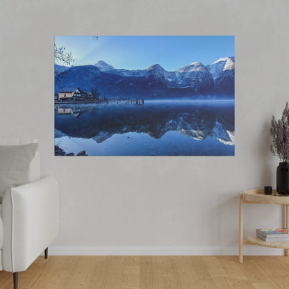 Large wall art showing a snow-capped mountain range reflected in a calm blue lake, with a small house and dock on the shore.